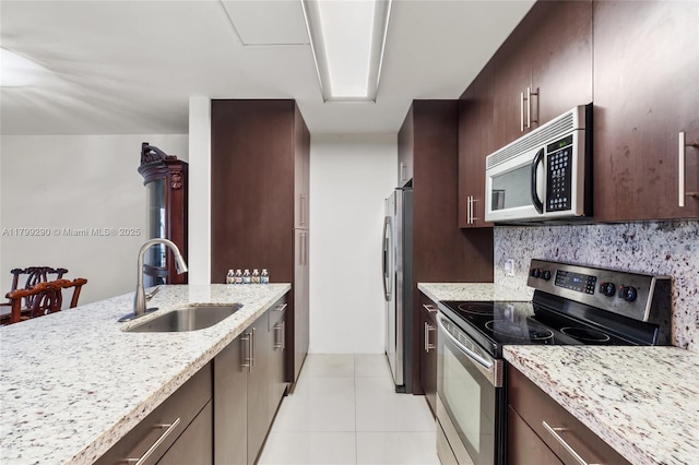 12501 SW 14th St Unit 108R, Pembroke Pines, FL 33027 - kitchen with stainless steel appliances, a sink, dark brown cabinets, and light stone countertops