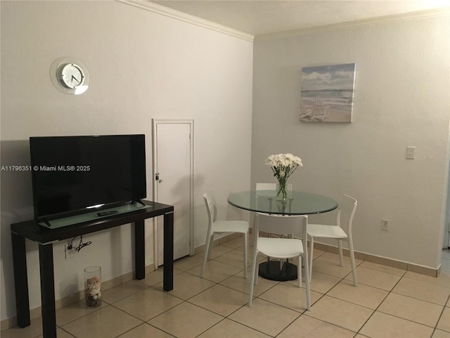 dining area featuring crown molding, baseboards, and light tile patterned floors