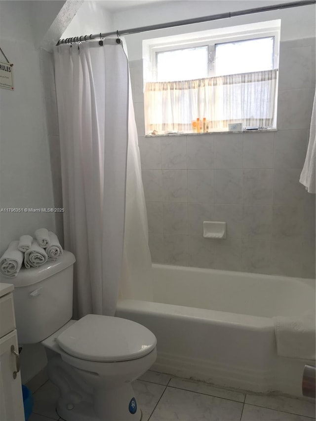 full bath featuring toilet, shower / bath combination with curtain, marble look tiles, and vanity