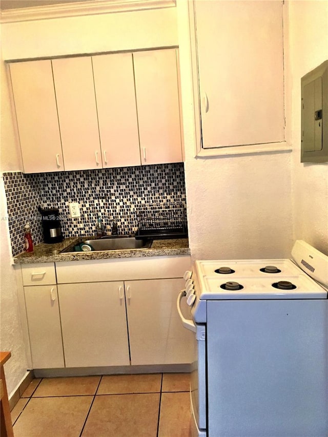laundry area with a sink, electric panel, and light tile patterned floors