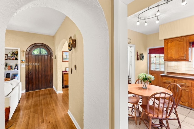 425 Cadagua Ave, Coral Gables, FL 33146 - foyer with arched walkways, a textured wall, light wood-style floors, and baseboards