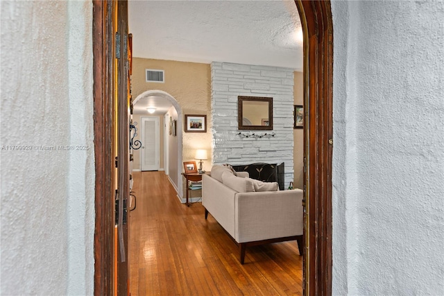 425 Cadagua Ave, Coral Gables, FL 33146 - corridor featuring arched walkways, a textured wall, hardwood / wood-style floors, and baseboards
