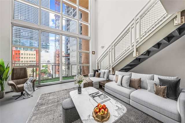 244 Biscayne Blvd Unit 645, Miami, FL 33132 - living area featuring finished concrete floors, a high ceiling, a city view, stairs, and a wall of windows