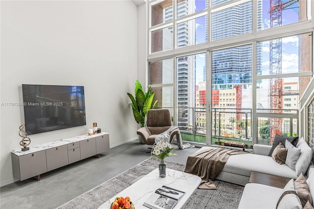 244 Biscayne Blvd Unit 645, Miami, FL 33132 - living room featuring plenty of natural light, a towering ceiling, a city view, and finished concrete flooring
