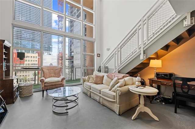244 Biscayne Blvd Unit 645, Miami, FL 33132 - living room featuring finished concrete flooring, a towering ceiling, healthy amount of natural light, stairs, and a city view