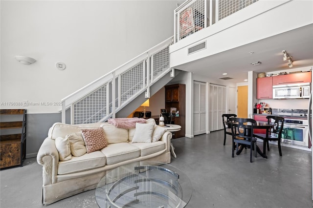 244 Biscayne Blvd Unit 645, Miami, FL 33132 - living area featuring finished concrete floors, stairway, and a towering ceiling