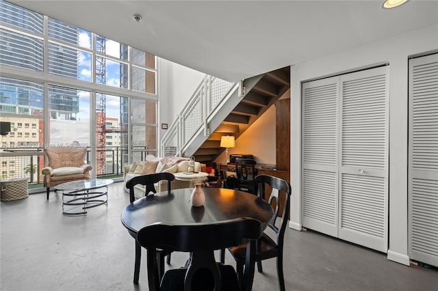 244 Biscayne Blvd Unit 645, Miami, FL 33132 - dining room featuring stairs, expansive windows, healthy amount of natural light, and concrete flooring