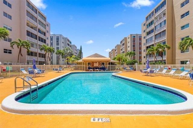community pool with fence and a patio area
