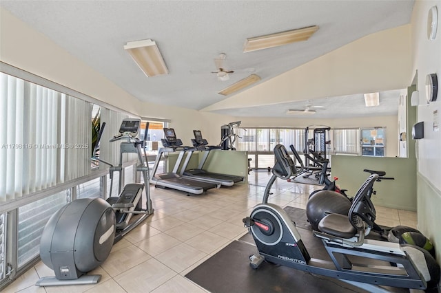 workout area with vaulted ceiling, healthy amount of natural light, and tile patterned floors