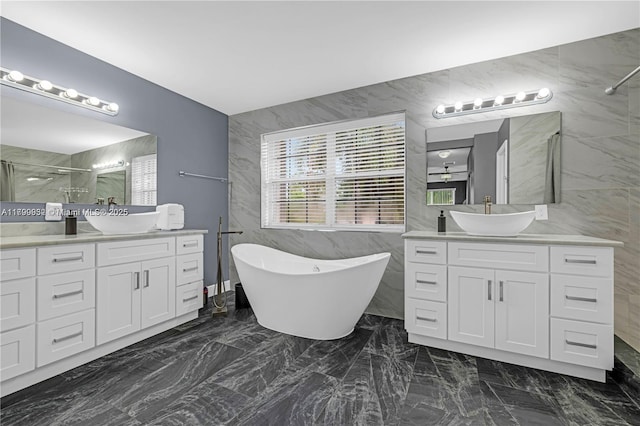 3372 SW 179th Ave, Miramar, FL 33029 - bathroom featuring tile walls, a marble finish shower, marble finish flooring, a freestanding tub, and two vanities