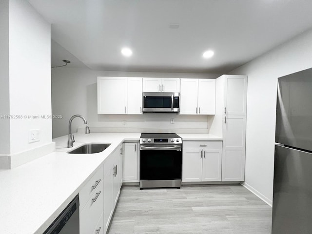 7950 W Mcnab Rd Unit 222, Tamarac, FL 33321 - kitchen with stainless steel appliances, a sink, white cabinets, light wood-type flooring, and recessed lighting