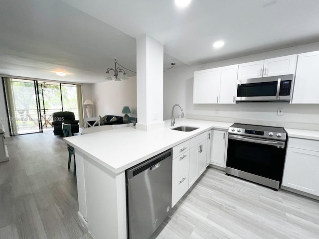 7950 W Mcnab Rd Unit 222, Tamarac, FL 33321 - kitchen featuring stainless steel appliances, a sink, open floor plan, light countertops, and a peninsula