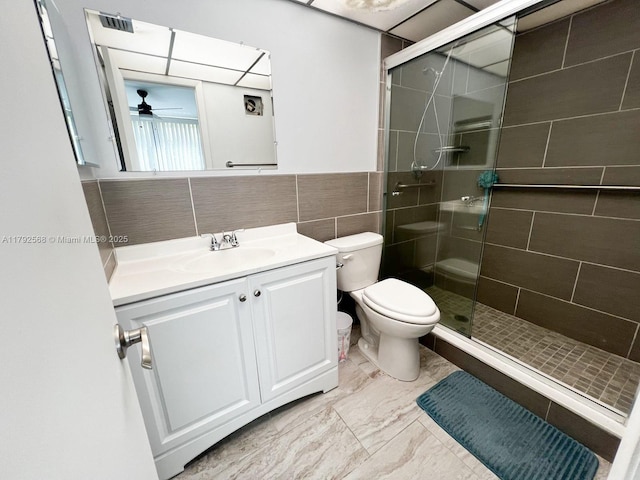 7950 W Mcnab Rd Unit 222, Tamarac, FL 33321 - bathroom featuring vanity, a stall shower, toilet, tile walls, and ceiling fan