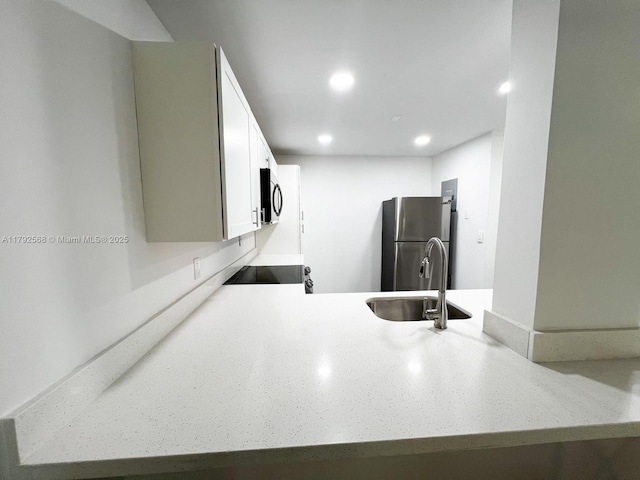 7950 W Mcnab Rd Unit 222, Tamarac, FL 33321 - kitchen with appliances with stainless steel finishes, a sink, recessed lighting, white cabinetry, and light stone counters