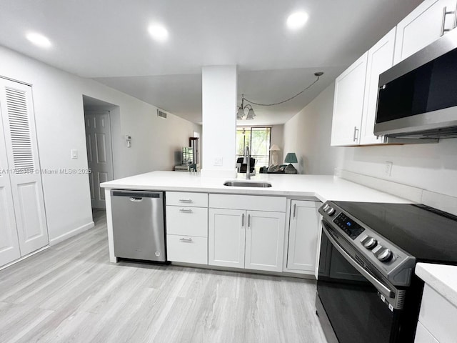 7950 W Mcnab Rd Unit 222, Tamarac, FL 33321 - kitchen with stainless steel appliances, a sink, light wood-style floors, white cabinetry, and light countertops