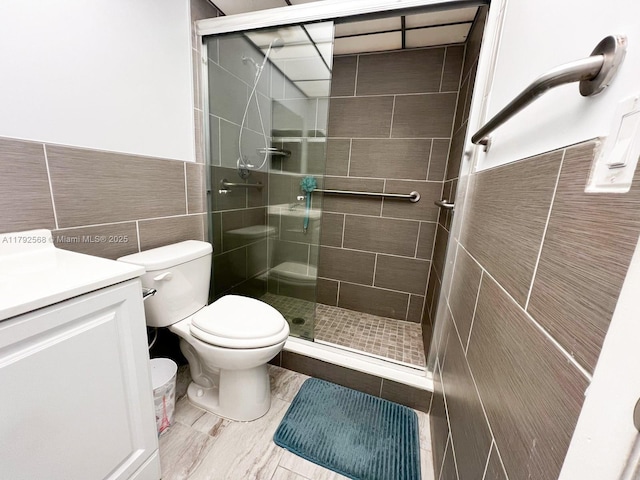 7950 W Mcnab Rd Unit 222, Tamarac, FL 33321 - bathroom with tile walls, a stall shower, vanity, toilet, and wainscoting