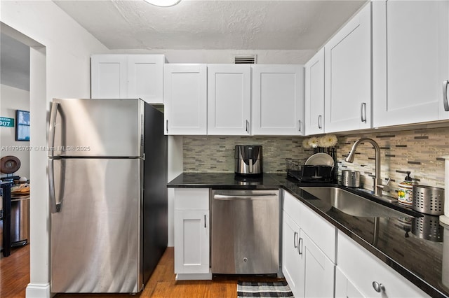 1470 NE 125th Ter Unit Ph9, North Miami, FL 33161 - kitchen with stainless steel appliances, a sink, white cabinets, wood finished floors, and a textured ceiling