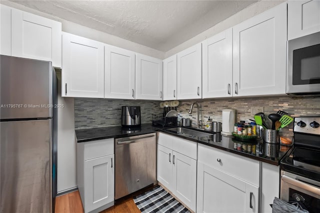 1470 NE 125th Ter Unit Ph9, North Miami, FL 33161 - kitchen with stainless steel appliances, a sink, white cabinets, and a textured ceiling