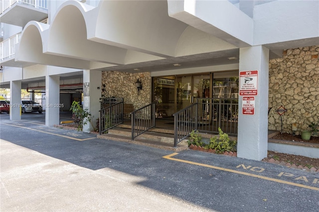 1470 NE 125th Ter Unit Ph9, North Miami, FL 33161 - doorway to property featuring stone siding, stucco siding, and a parking lot