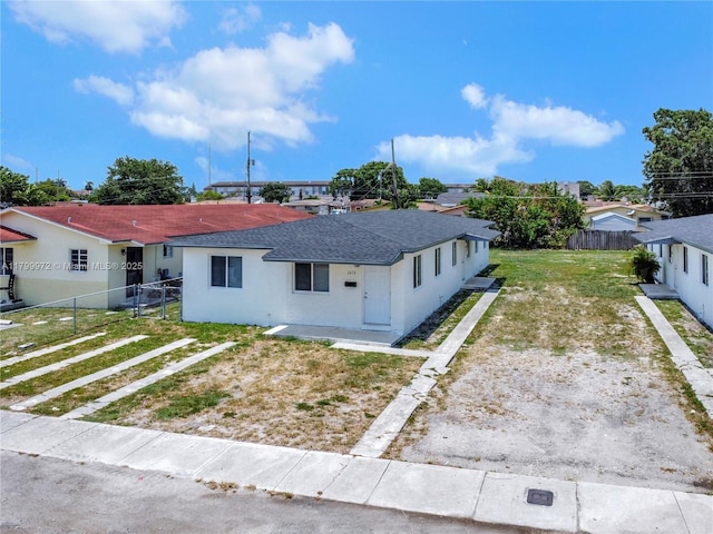 2439-41 NW 81st Ter, Miami, FL 33147 - view of front facade with roof with shingles, fence, driveway, and stucco siding