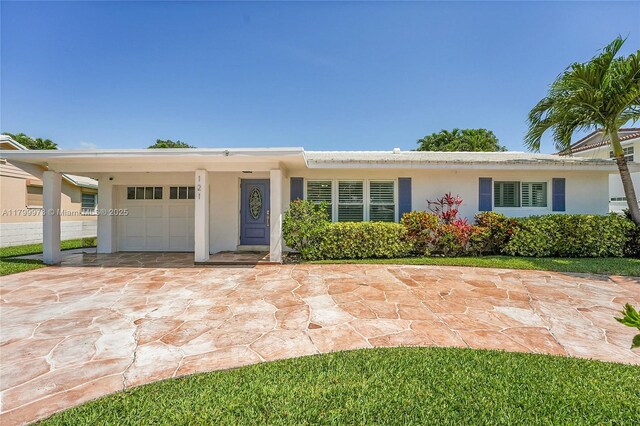 121 Tacoma Ln, Palm Beach Shores, FL 33404 - view of front of property with a garage, stucco siding, and driveway