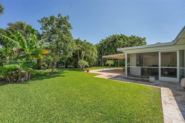 121 Tacoma Ln, Palm Beach Shores, FL 33404 - view of grassy yard with a sunroom, a patio area, and a ceiling fan
