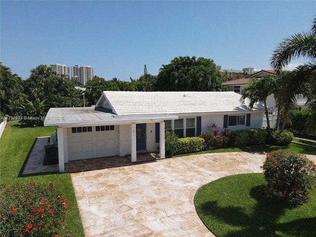 121 Tacoma Ln, Palm Beach Shores, FL 33404 - ranch-style home featuring an attached garage, driveway, stucco siding, and a front lawn
