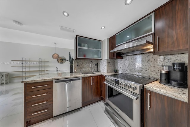 kitchen with stainless steel appliances, light tile patterned floors, a sink, under cabinet range hood, and a peninsula