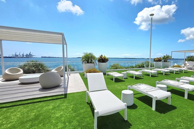 view of property's community with a water view and a yard