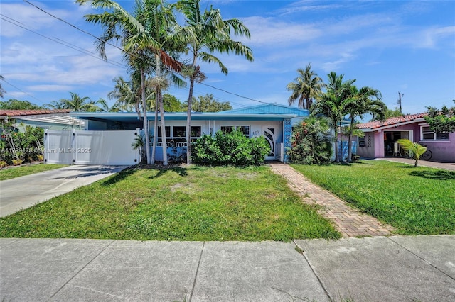 1155 Hayes St, Hollywood, FL 33019 - view of front facade featuring a front lawn, driveway, and an attached carport