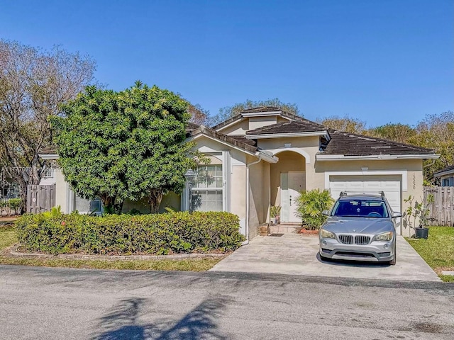 12250 SW 144th Ter, Miami, FL 33186 - view of front of property featuring a garage, stucco siding, driveway, and fence