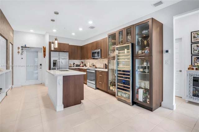 8301 NW 41st St Unit B-305, Doral, FL 33166 - kitchen featuring stainless steel appliances, light countertops, wine cooler, decorative backsplash, and glass insert cabinets