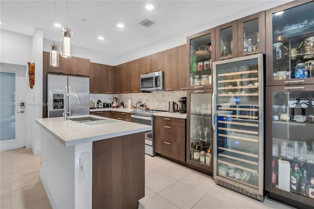 8301 NW 41st St Unit B-305, Doral, FL 33166 - kitchen featuring appliances with stainless steel finishes, wine cooler, light countertops, tasteful backsplash, and hanging light fixtures