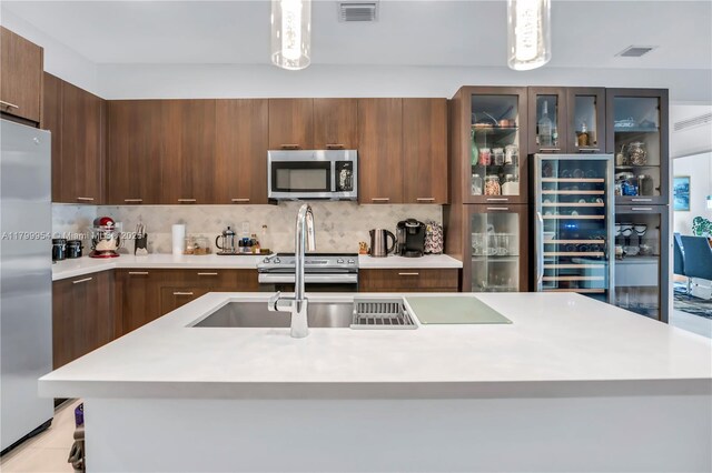 8301 NW 41st St Unit B-305, Doral, FL 33166 - kitchen featuring appliances with stainless steel finishes, beverage cooler, light countertops, decorative backsplash, and modern cabinets