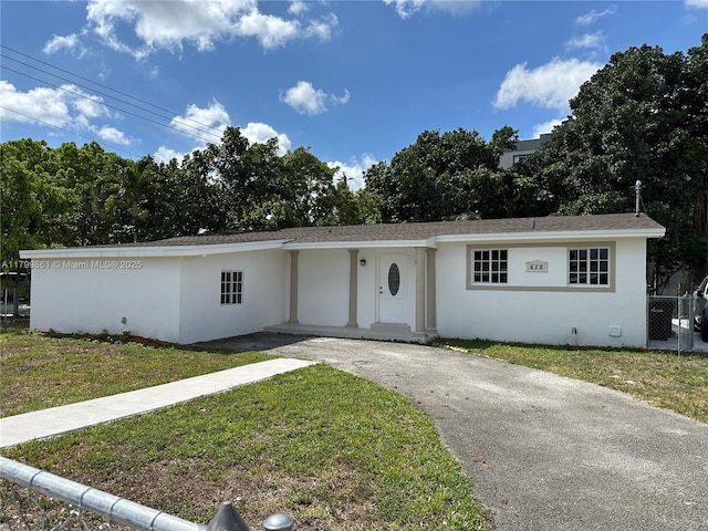 ranch-style home featuring stucco siding and asphalt driveway