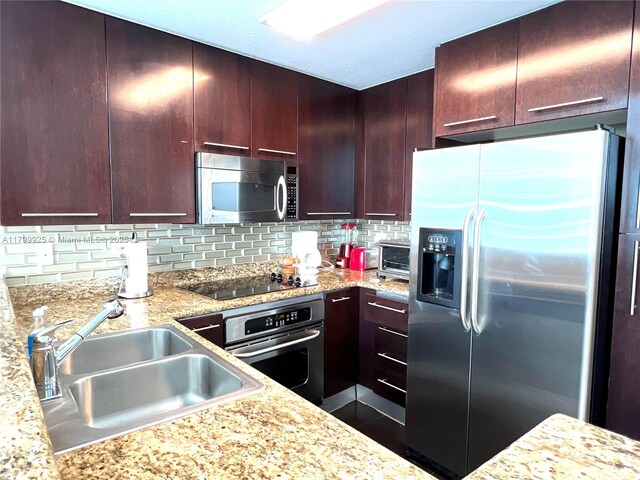 6515 Collins Ave Unit 1801, Miami Beach, FL 33141 - kitchen featuring stainless steel appliances, backsplash, and light stone counters