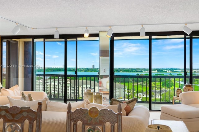 2450 Presidential Way Unit 1607, West Palm Beach, FL 33401 - sunroom with rail lighting, a water view, and healthy amount of natural light