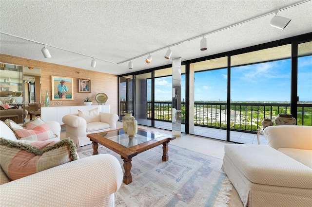 2450 Presidential Way Unit 1607, West Palm Beach, FL 33401 - living area featuring track lighting, a wall of windows, and healthy amount of natural light