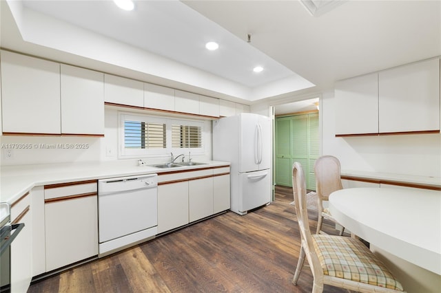 2450 Presidential Way Unit 1607, West Palm Beach, FL 33401 - kitchen with white appliances, a sink, a tray ceiling, dark wood finished floors, and white cabinets