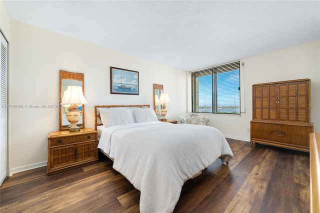 2450 Presidential Way Unit 1607, West Palm Beach, FL 33401 - bedroom featuring baseboards, dark wood-style floors, and a closet