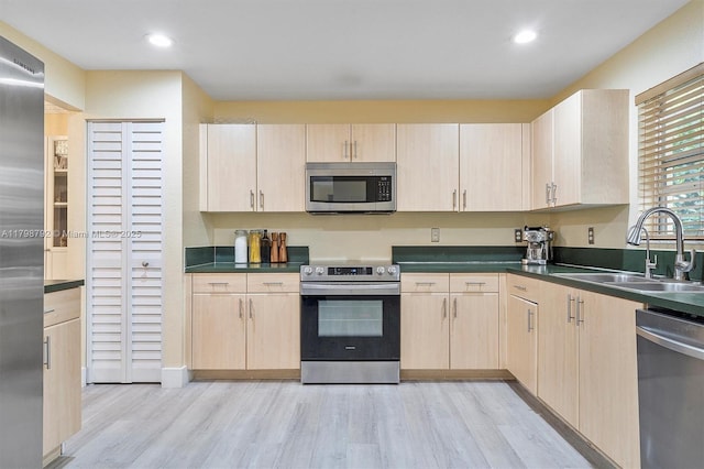 4161 W Silverado Cir, Davie, FL 33024 - kitchen with appliances with stainless steel finishes, light brown cabinets, a sink, light wood finished floors, and dark countertops