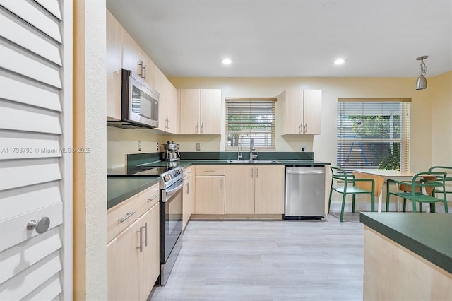 4161 W Silverado Cir, Davie, FL 33024 - kitchen with appliances with stainless steel finishes, light brown cabinets, a sink, dark countertops, and light wood finished floors