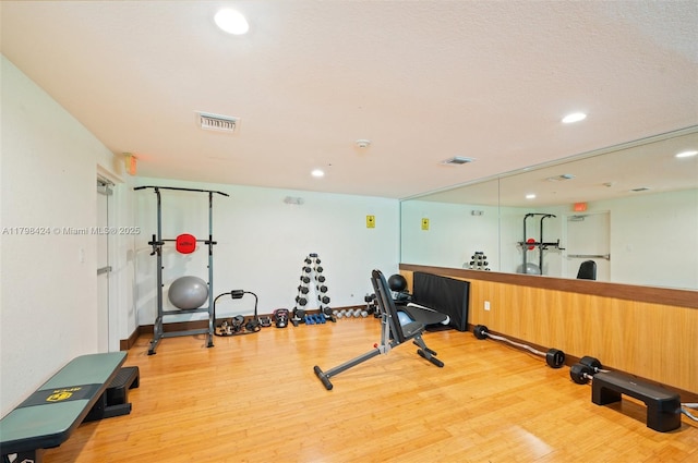 exercise area with wood finished floors and recessed lighting