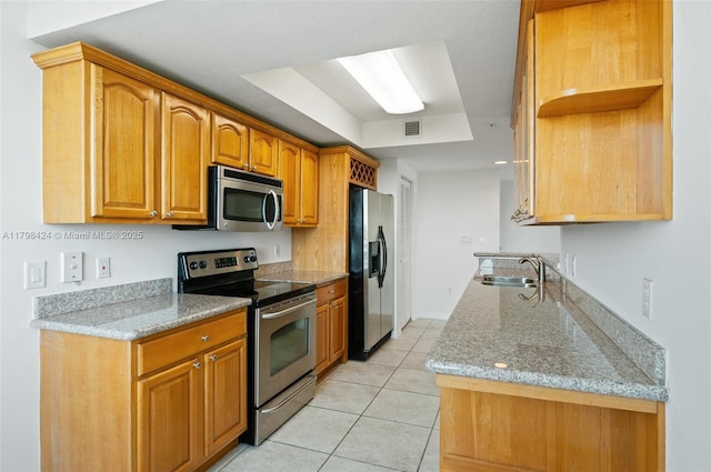 kitchen featuring stainless steel appliances, a sink, light tile patterned floors, brown cabinetry, and open shelves