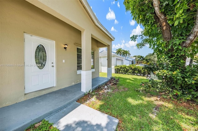14480 SW 145th Pl, Miami, FL 33186 - view of exterior entry featuring a yard, stucco siding, and a porch