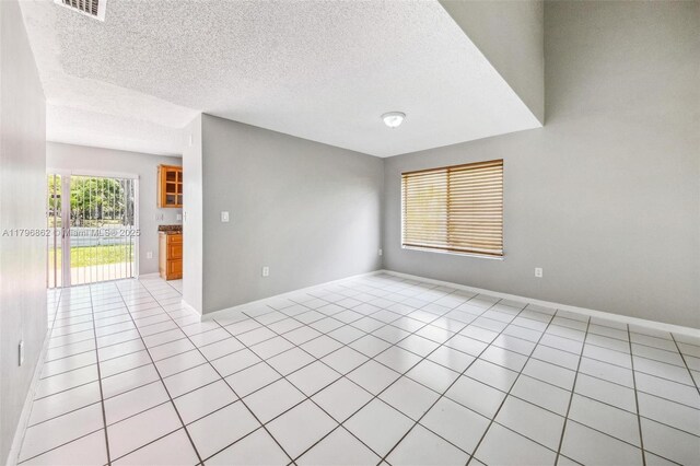 14480 SW 145th Pl, Miami, FL 33186 - unfurnished room with light tile patterned floors, baseboards, and a textured ceiling