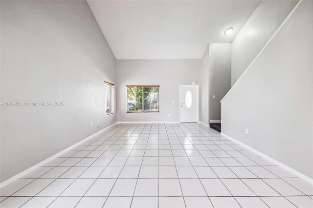 14480 SW 145th Pl, Miami, FL 33186 - unfurnished living room featuring baseboards, light tile patterned floors, and high vaulted ceiling