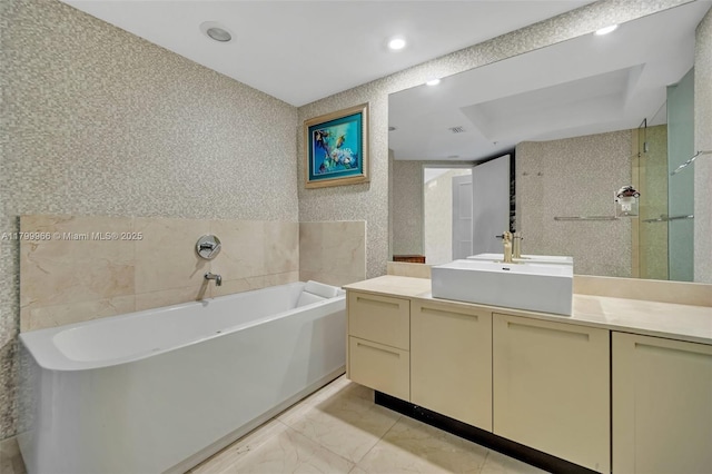 full bathroom featuring a bath, vanity, marble finish flooring, and recessed lighting