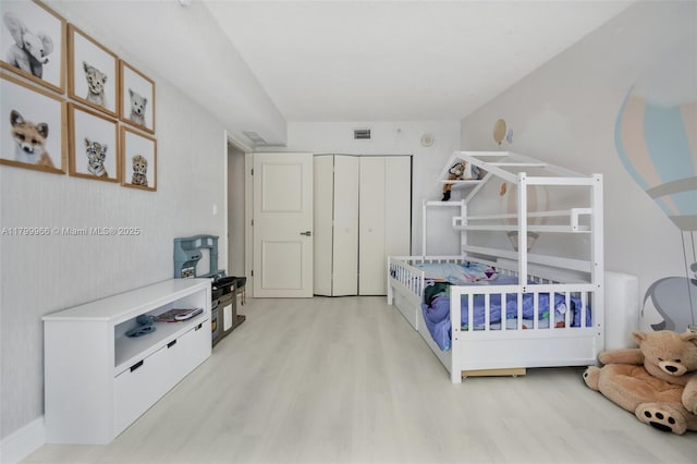 bedroom featuring light wood finished floors and a closet