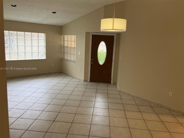 17691 SW 4th Ct, Pembroke Pines, FL 33029 - foyer entrance with vaulted ceiling, light tile patterned floors, a textured ceiling, and baseboards